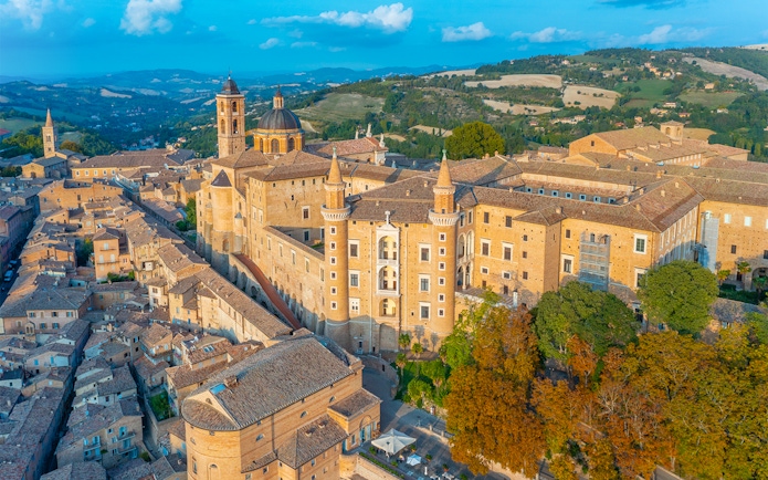Aerial view of Urbino Ducal Palace and surrounding cityscape in Italy.