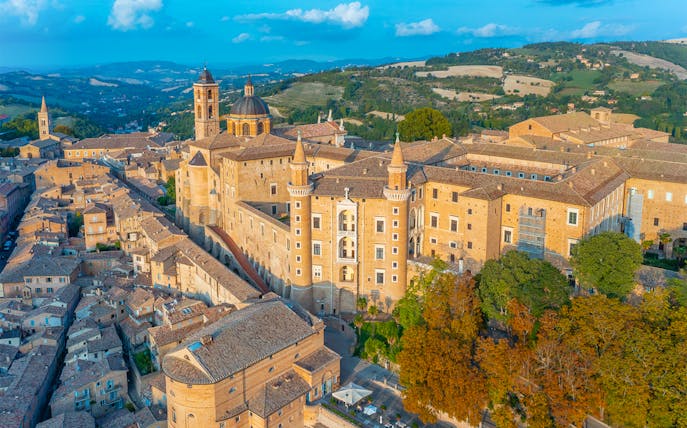 Aerial view of Urbino Ducal Palace and surrounding cityscape in Italy.