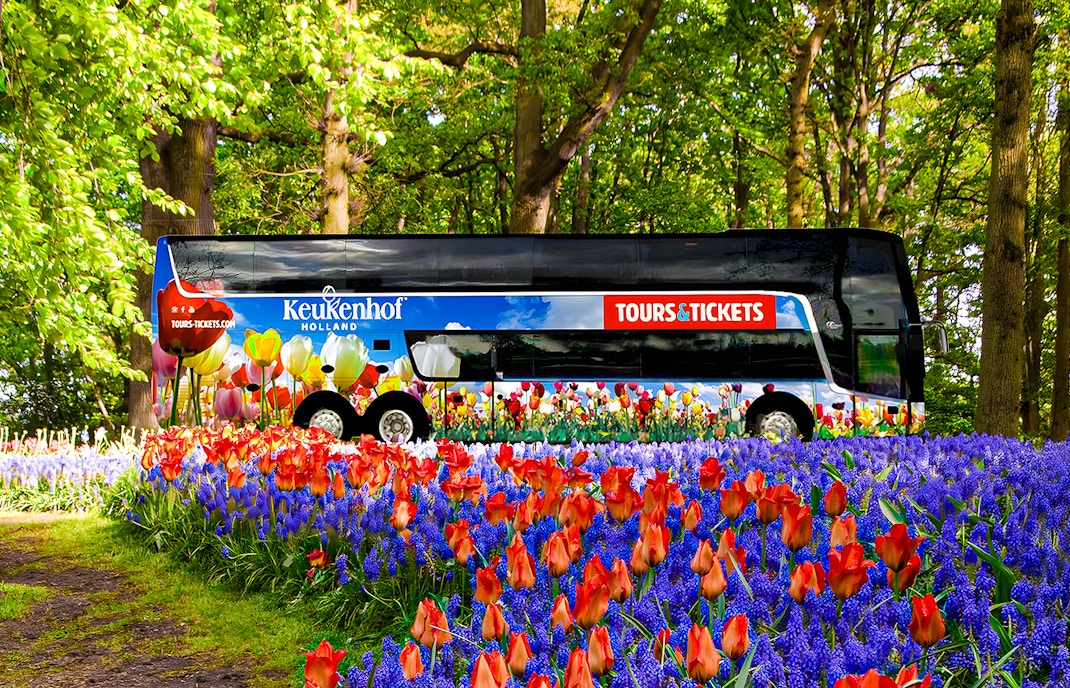 Keukenhof tour bus surrounded by vibrant tulips and hyacinths in a lush garden.