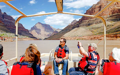 Guests on a boat tour at Grand Canyon West Rim with scenic views of canyon walls.