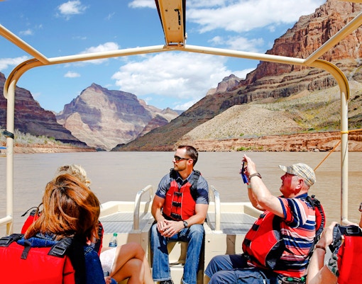 Guests on a boat during Grand Canyon West Rim helicopter tour with floor landing and boat ride.