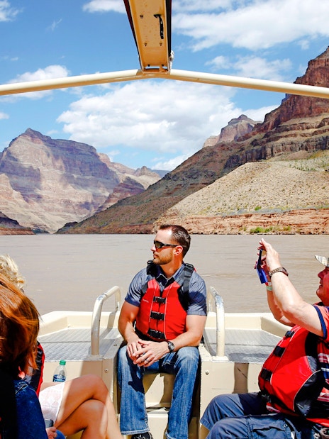 Guests on a boat tour at Grand Canyon West Rim with scenic views of canyon walls.