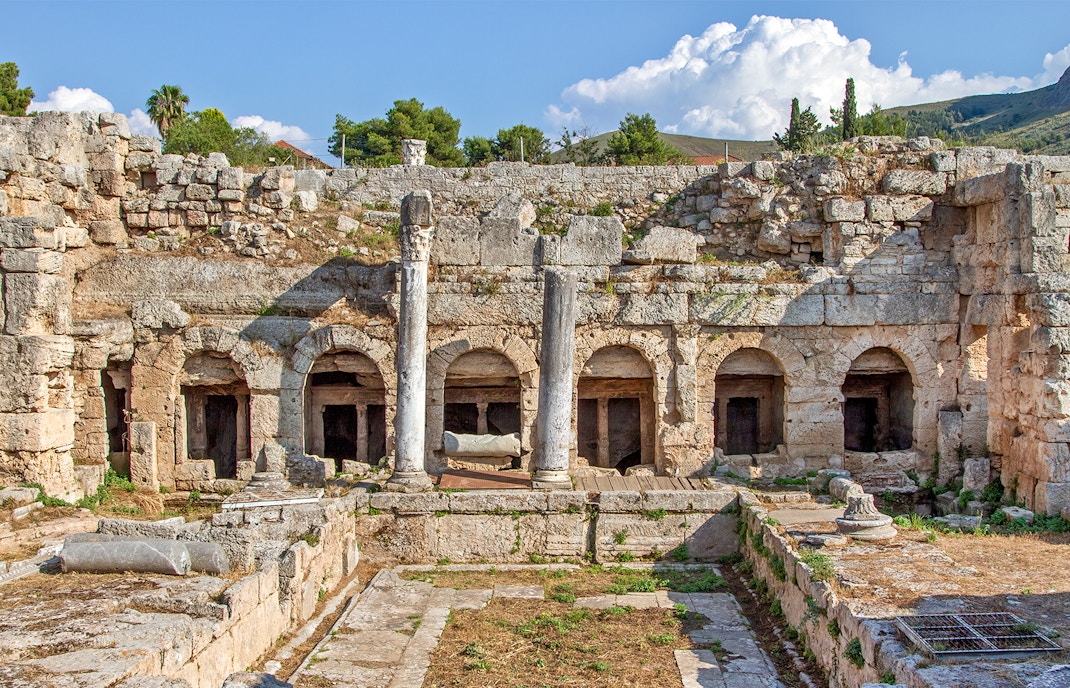 Ancient Fountain of Peirene ruins with stone arches and columns in Corinth, Greece.