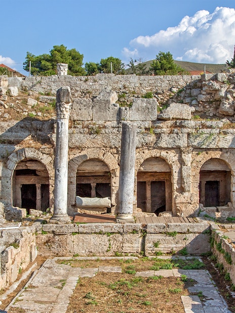 Ancient Fountain of Peirene ruins with stone arches and columns in Corinth, Greece.