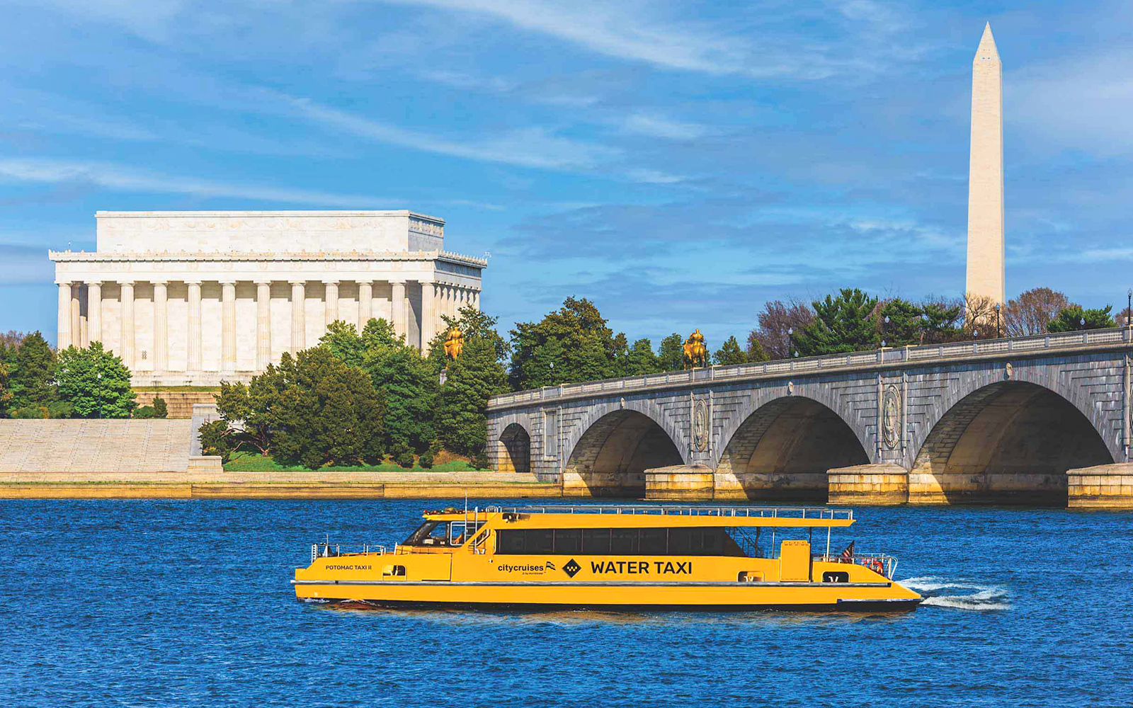 Yellow water taxi on Potomac River with Lincoln Memorial and Washington Monument in background.