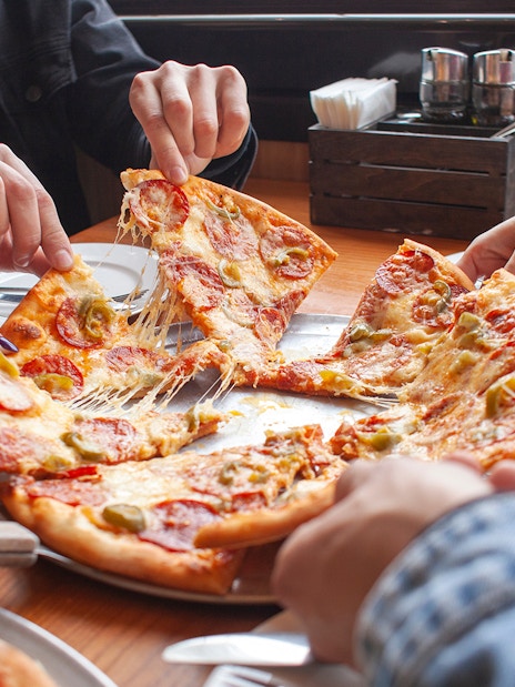 Group sharing pizza at a restaurant in Milano Bovisa.