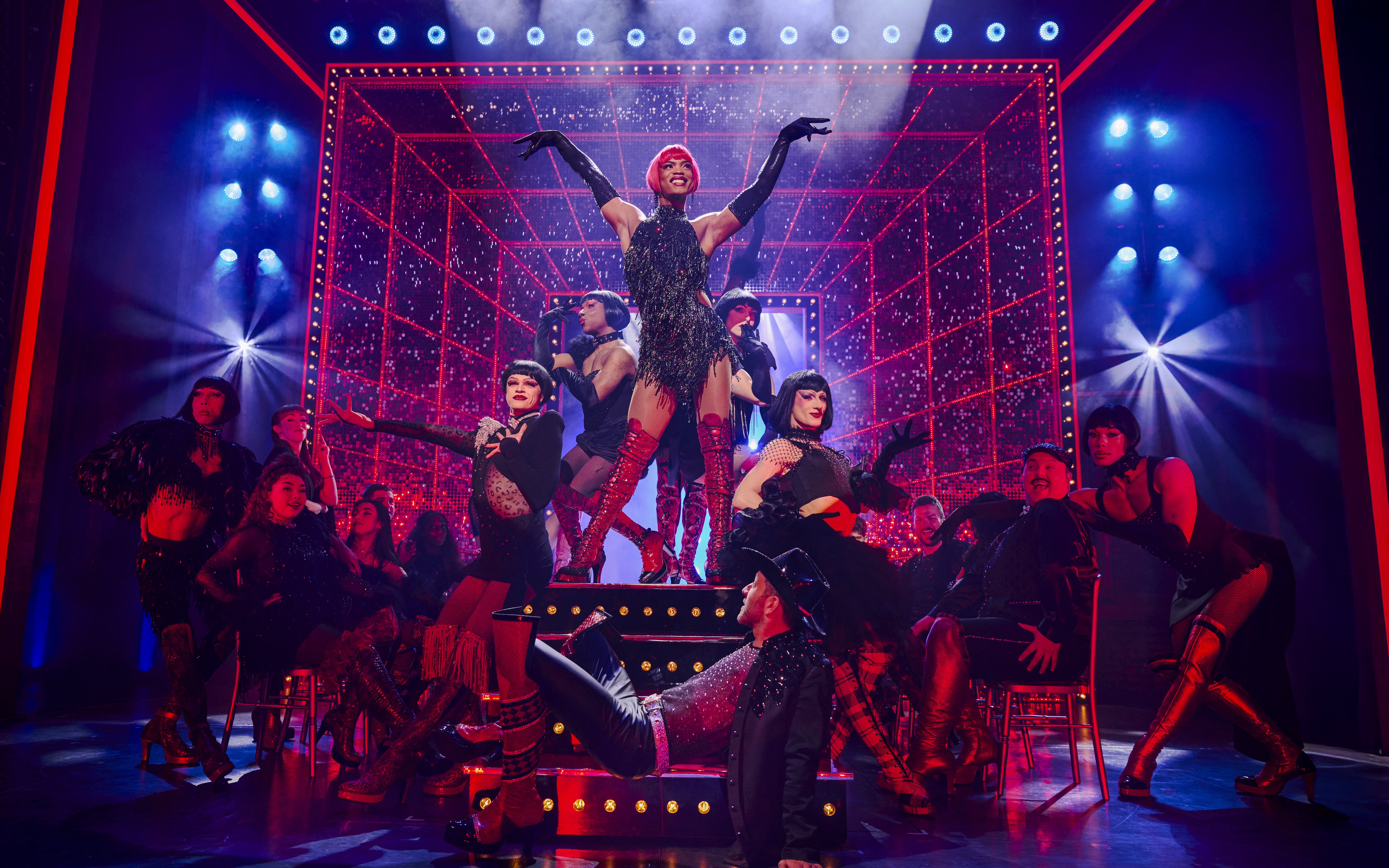 Performers in vibrant costumes on stage during a Kinky Boots production.