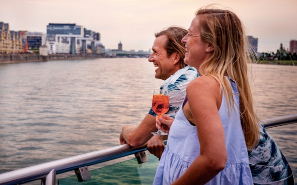 Couple enjoying a sunset view on a Cologne evening panorama cruise.