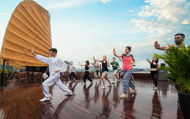 Guests practicing tai chi on deck during Lan Ha Bay 5-Star Premium Cruise.