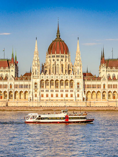 Cruise boat on the Danube River with Budapest Parliament in the background.
