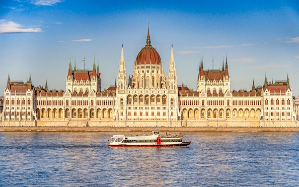 Cruise boat on the Danube River with Budapest Parliament in the background.