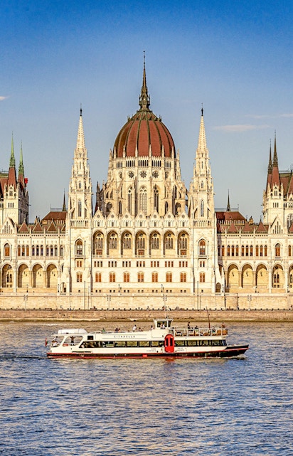 Cruise boat on the Danube River with Budapest Parliament in the background.