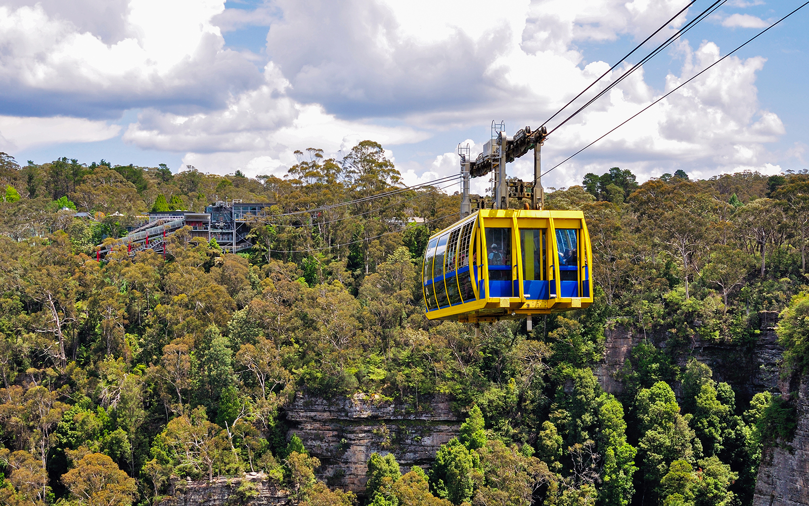 Cable car traversing the Blue Mountains, Sydney, with lush forest below.