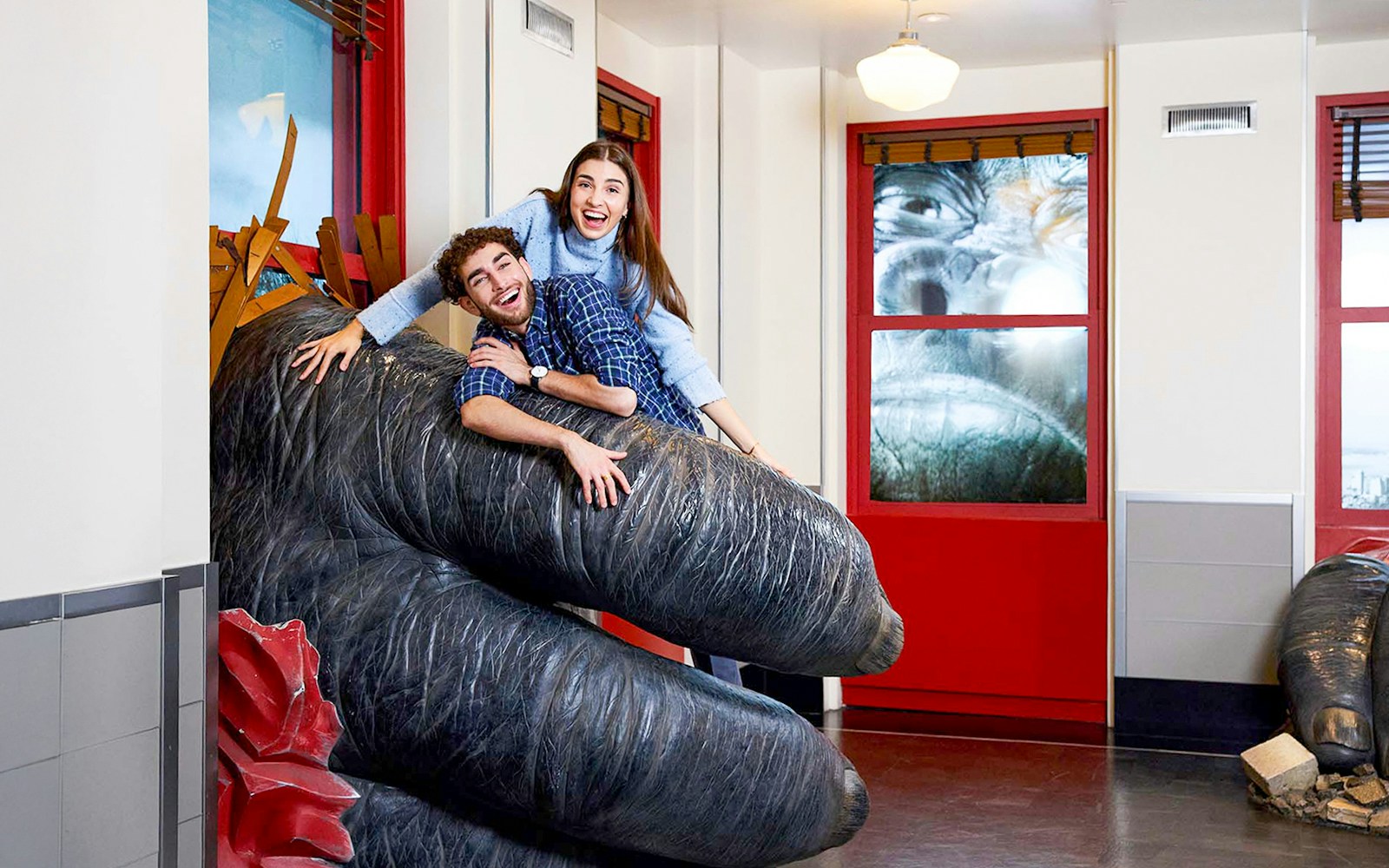 People posing on King Kong's hand inside the Empire State Building, NYC.