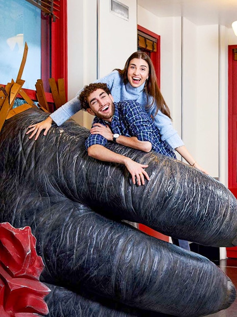 People posing on King Kong's hand inside the Empire State Building, NYC.