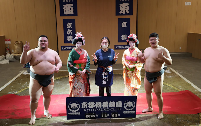 Sumo wrestlers and geishas at Kyoto Sumo Club event with a staff member.