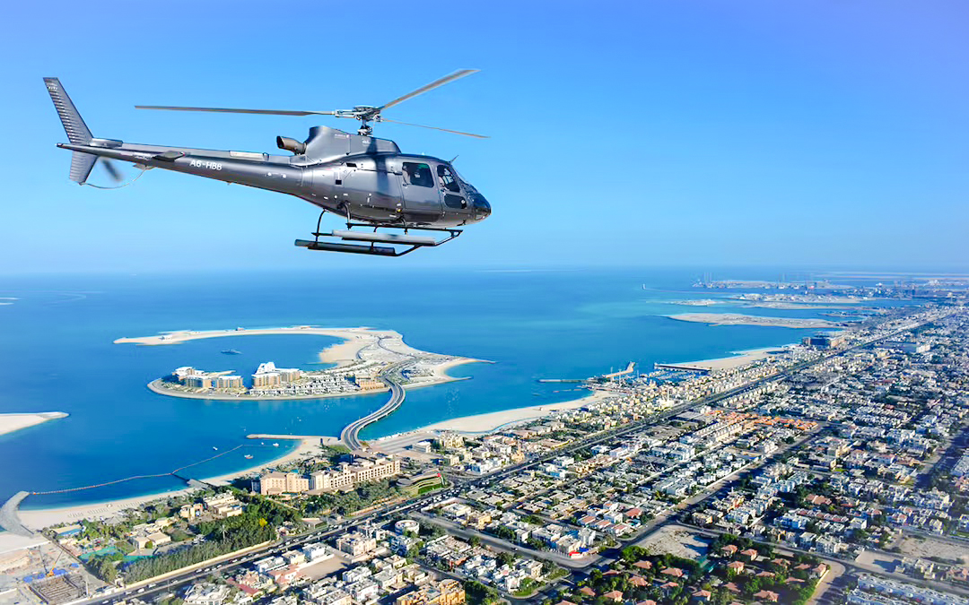 Helicopter flying over Dubai coastline with Palm Jumeirah in view.
