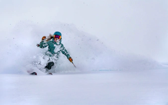 Skier navigating fresh powder snow, showcasing Ikon Pass experience.
