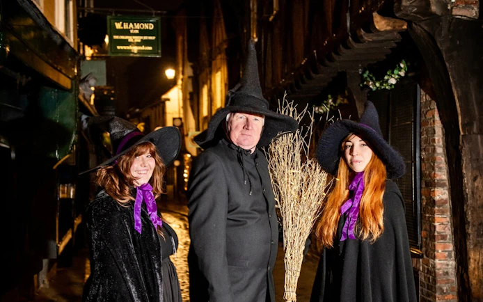 Three people in witch costumes on a York Old Town street during the Witches & History Walking Tour.