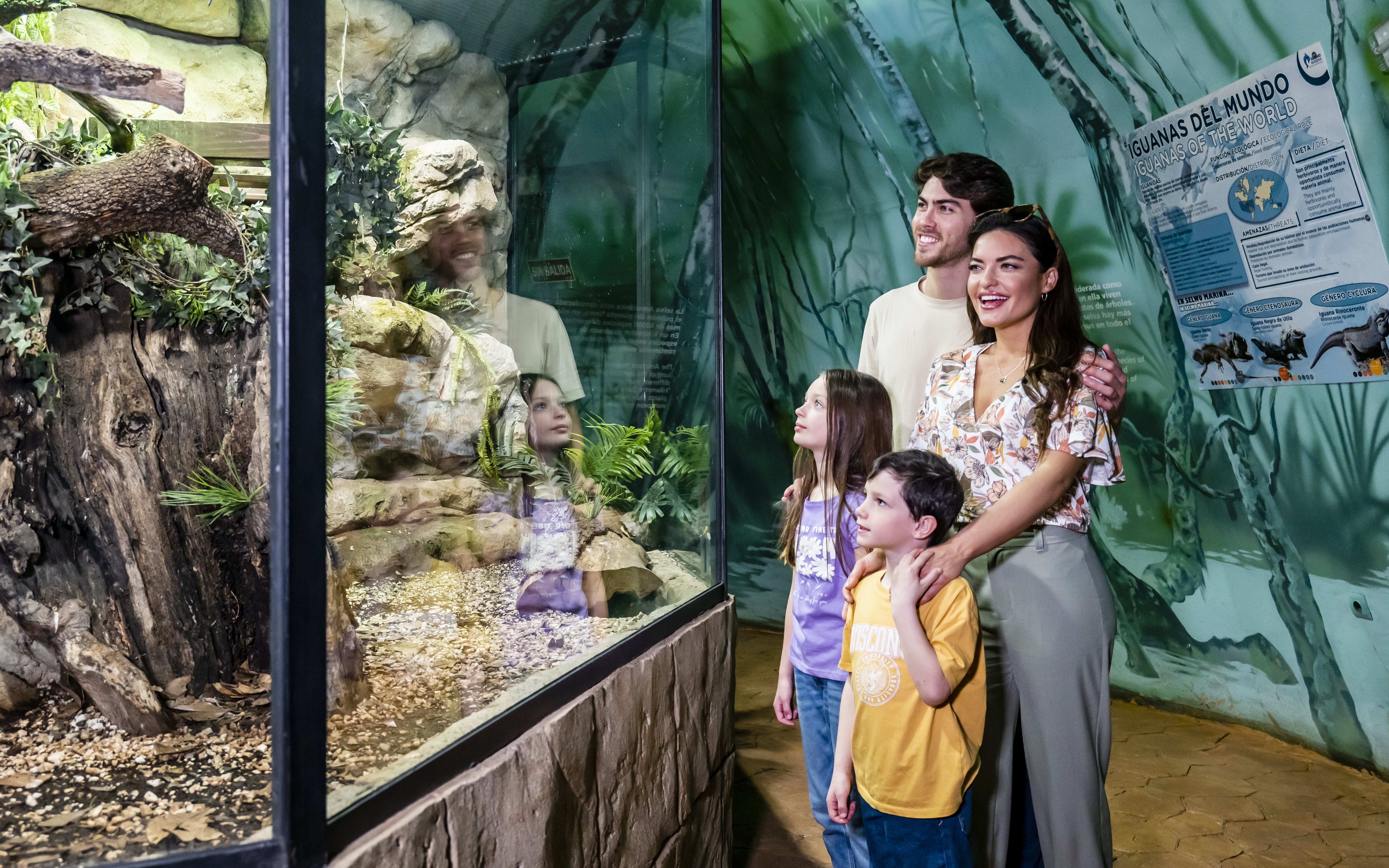Visitors with kids observing Amazon aquarium at Selwo Marina.
