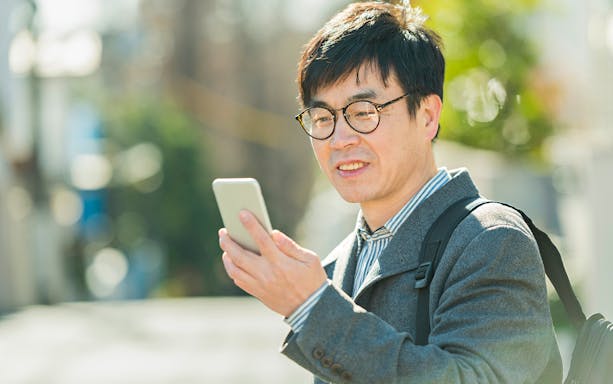 Man using smartphone outdoors, representing Korea 4G Tourist eSIM usage.