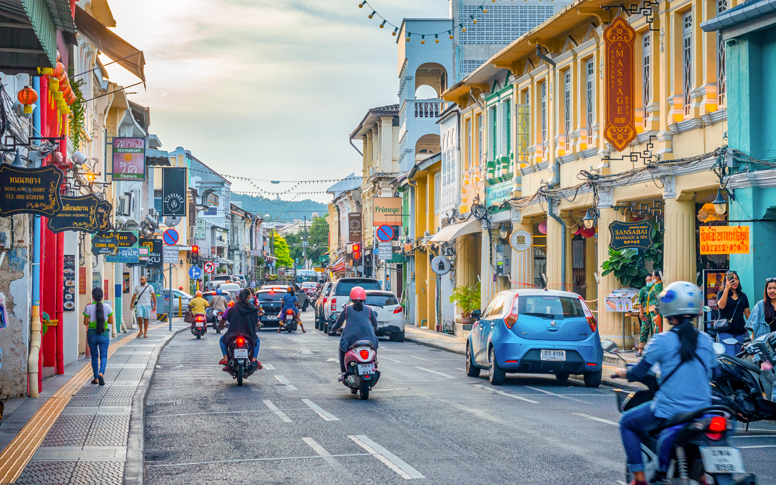 Old town street with motorbikes and vintage buildings in Phuket, Thailand.