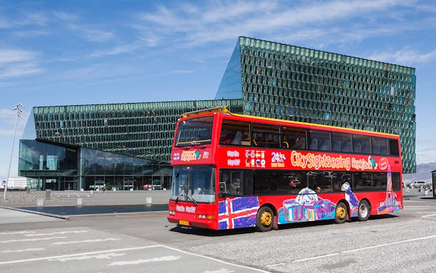 Red double-decker bus in front of Harpa Concert Hall, Reykjavik Hop-On Hop-Off Tour.
