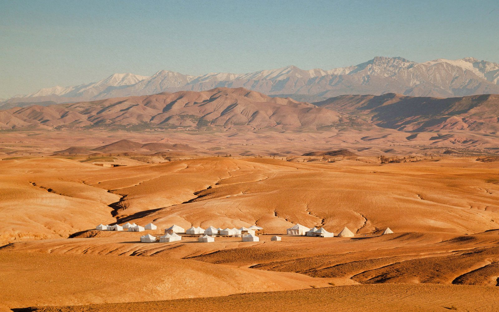 Desert landscape with tents in Agafay, Morocco, ideal for quad biking adventures.