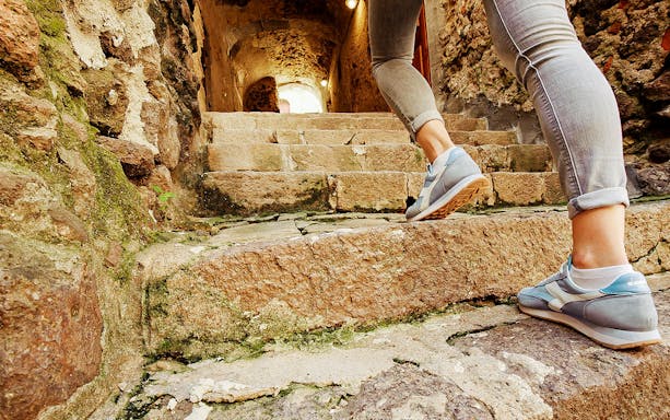 Walking up stone steps in Castelsardo during guided tour.
