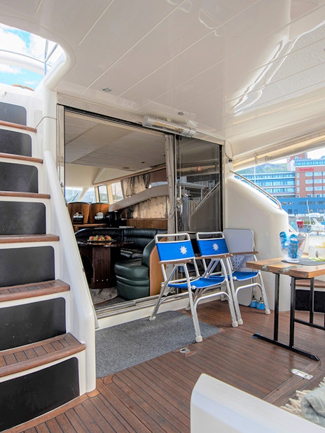 Inside view of a Whale Watching boat in Skjervøy with seating and table setup.