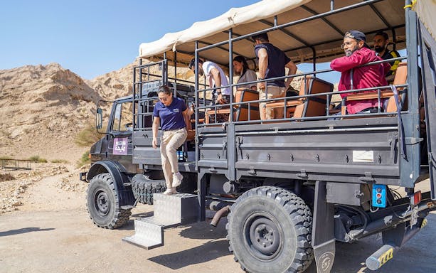 Visitors exiting a UniMog during a guided tour at Mleiha Archeological Centre, UAE.