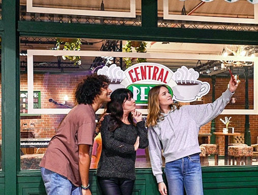 Visitors taking a selfie at Central Perk set during The Friends Experience tour.