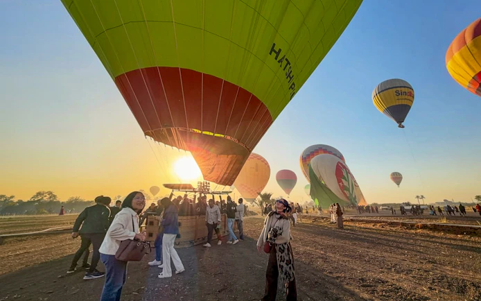 Hot air balloons preparing for flight at sunrise in Luxor, Egypt.