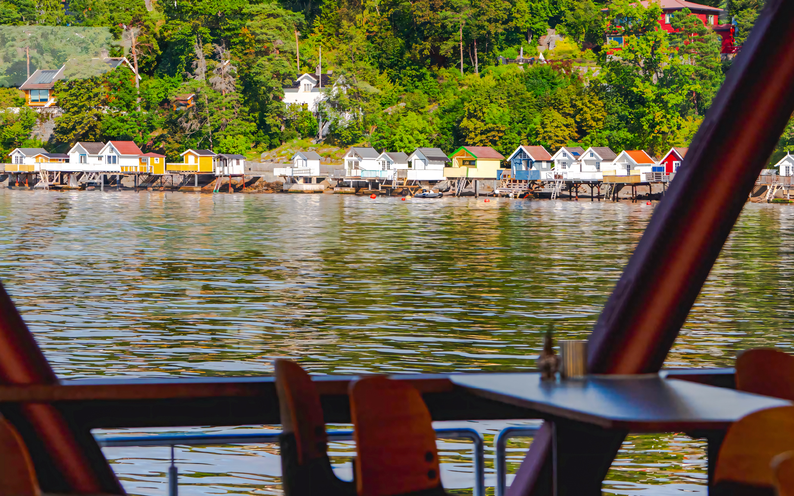 Colorful houses along Oslo fjord viewed from a cruise ship deck.