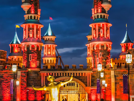 Vialand Theme Park entrance with illuminated castle towers at night.