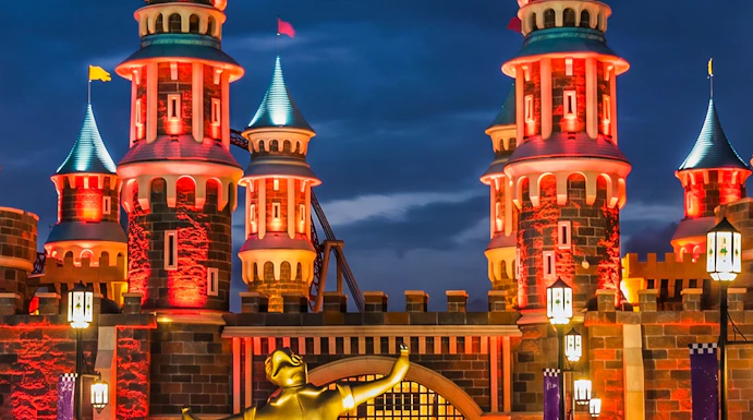 Vialand Theme Park entrance with illuminated castle towers at night.