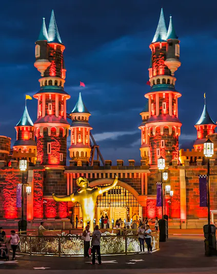 Vialand Theme Park entrance with illuminated castle towers at night.
