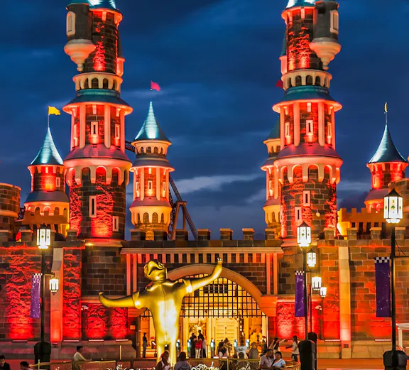 Vialand Theme Park entrance with illuminated castle towers at night.