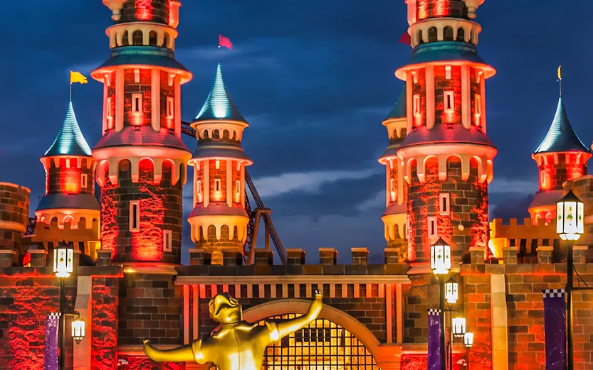 Vialand Theme Park entrance with illuminated castle towers at night.