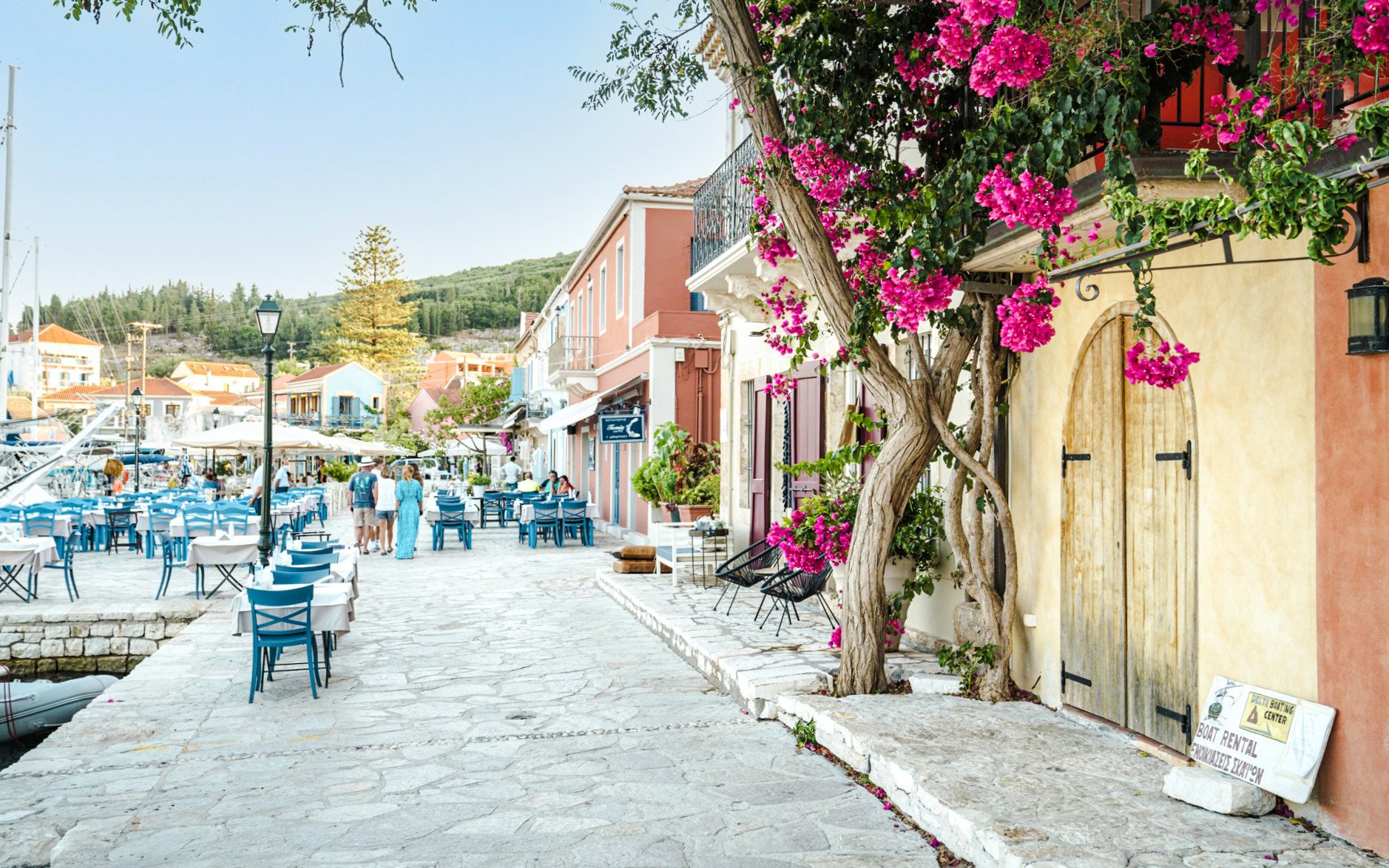 Fiskardo village waterfront with outdoor cafes and colorful buildings, Kefalonia island, Greece.