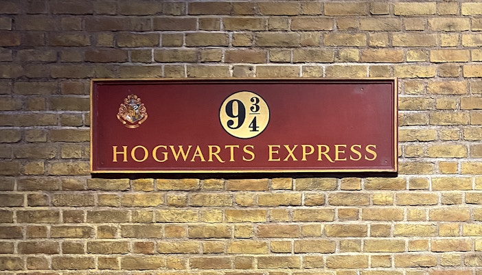 Platform 9¾ sign at Harry Potter studio tour, featuring Hogwarts Express emblem.