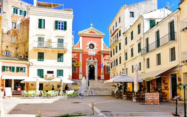 Spilia Square in Corfu, Greece, featuring colorful buildings and outdoor cafes.