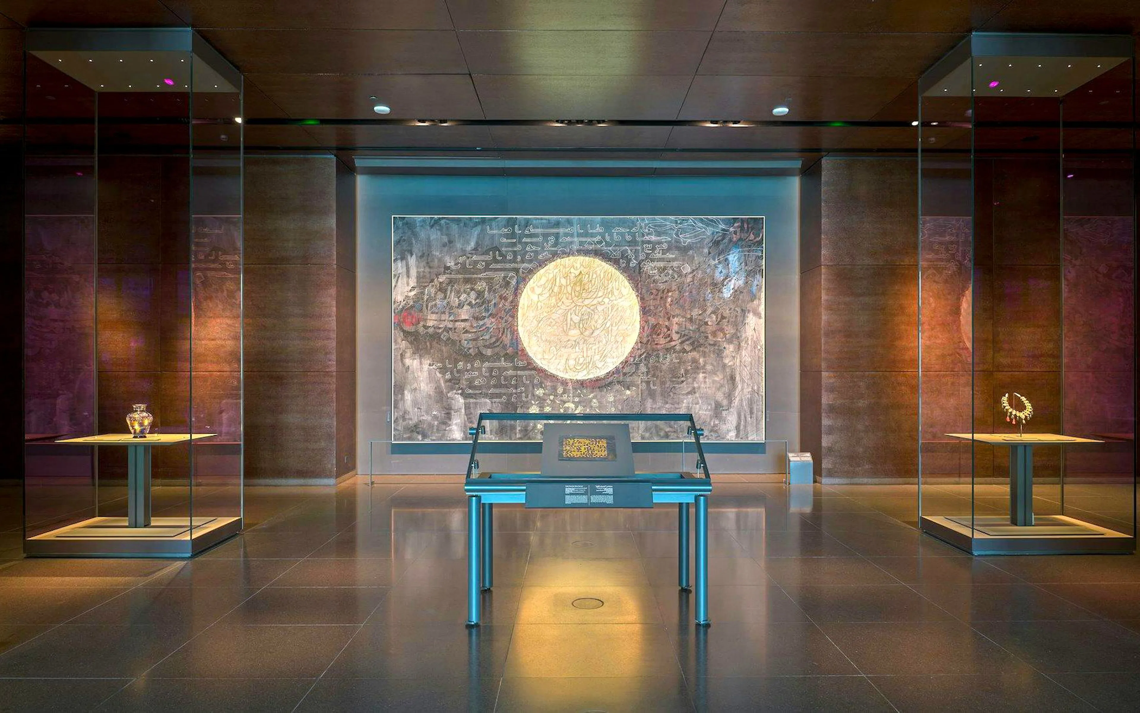 Exhibit hall at Museum of Islamic Art featuring a large circular artwork and display cases.