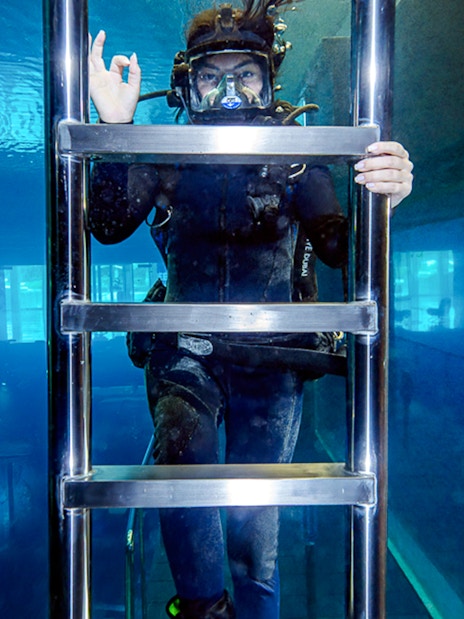 Diver exploring underwater structure during Sunken City Walk.