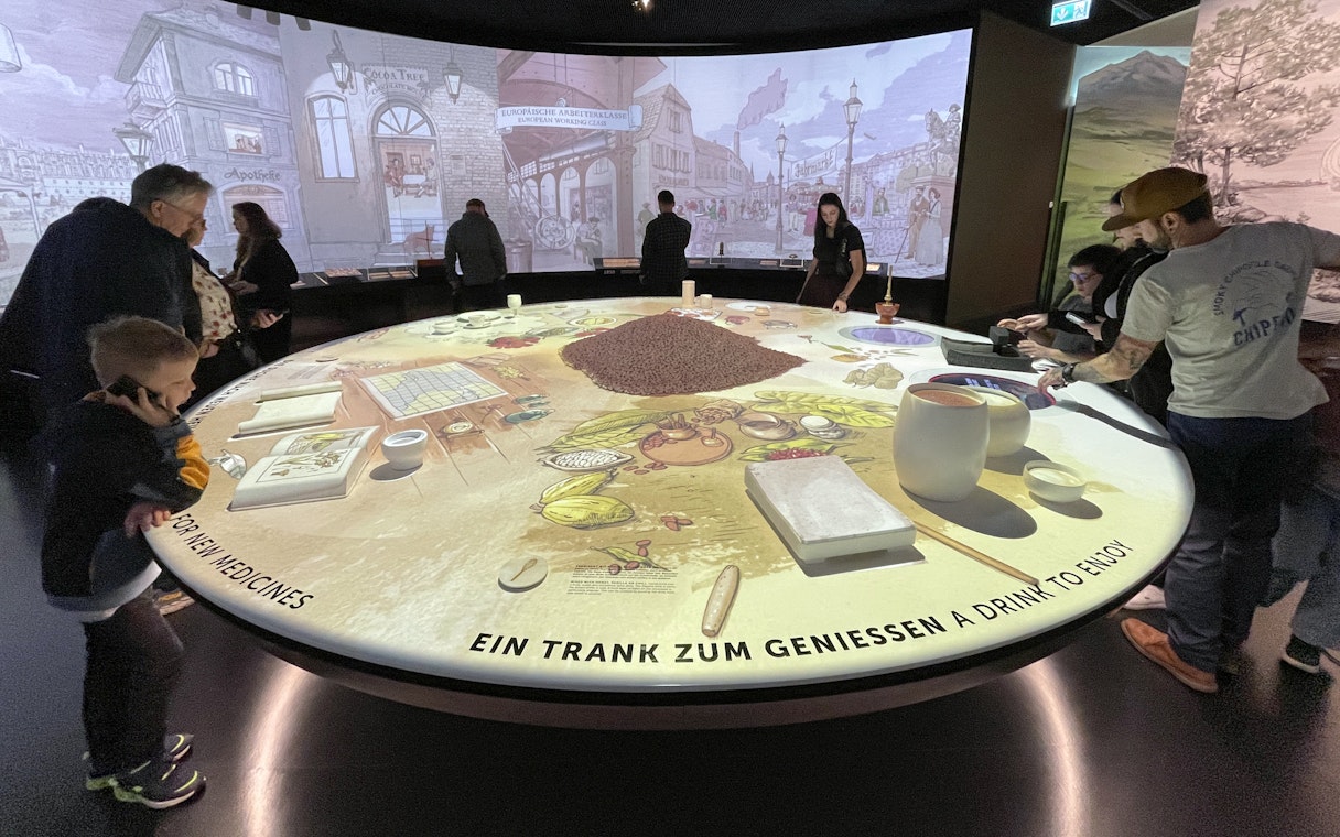 Visitors exploring interactive chocolate exhibit at Lindt Home of Chocolate Museum, Zurich.