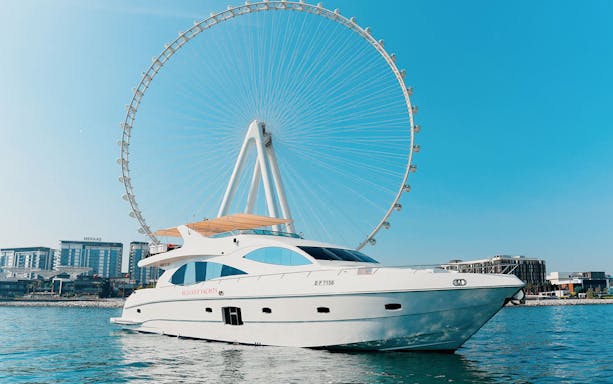 Bluewater yacht with Ain Dubai Wheel in the background on a sunny day.