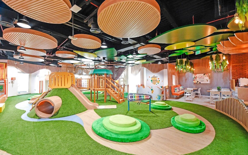 Indoor play area with slides and climbing structures at Orange Wheels, Global Village, Dubai.