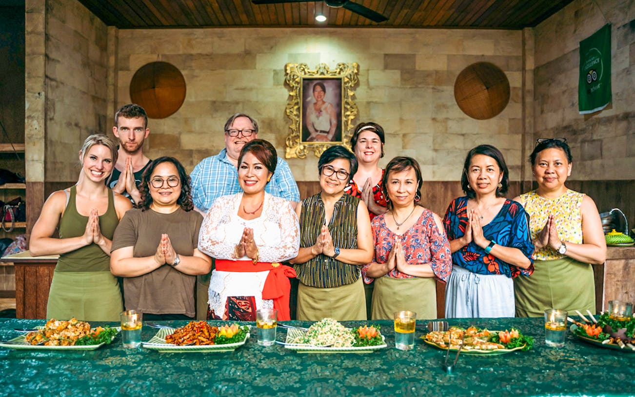 Group at Paon Bali Cooking Class in Ubud, standing behind a table with prepared dishes.