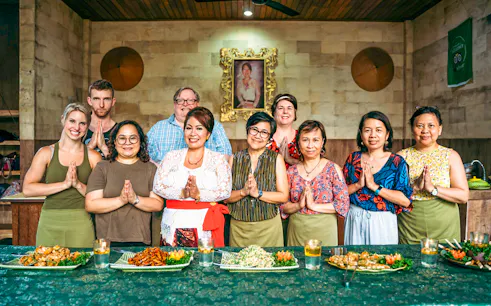 Group at Paon Bali Cooking Class in Ubud, standing behind a table with prepared dishes.