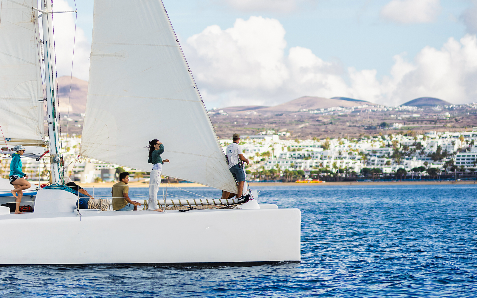 Tourists on a sailboat in Lanzarote waters, watching for whales and dolphins.